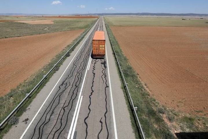 Las líneas de alquitrán y el motorista en la carretera Las líneas de alquitrán y el motorista en la carretera