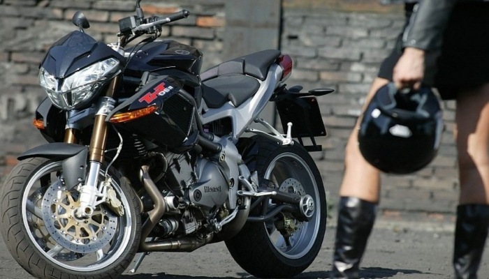 hombre llevando casco hacia la moto