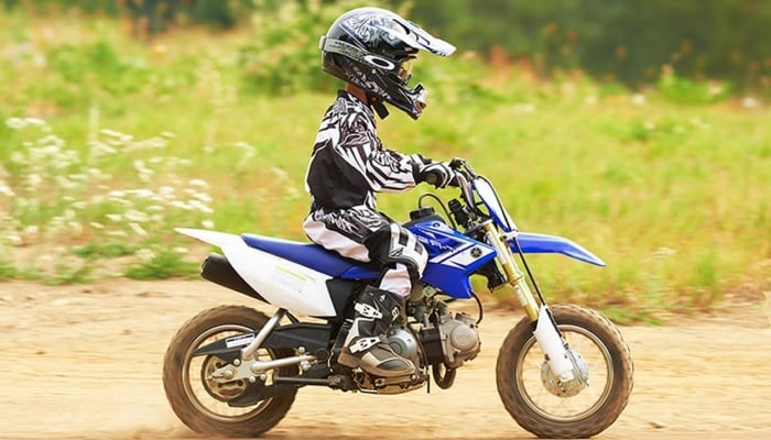 niño montando en una moto de color azul