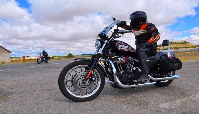 motorista saludando en V a otro al otro lado de una carretera