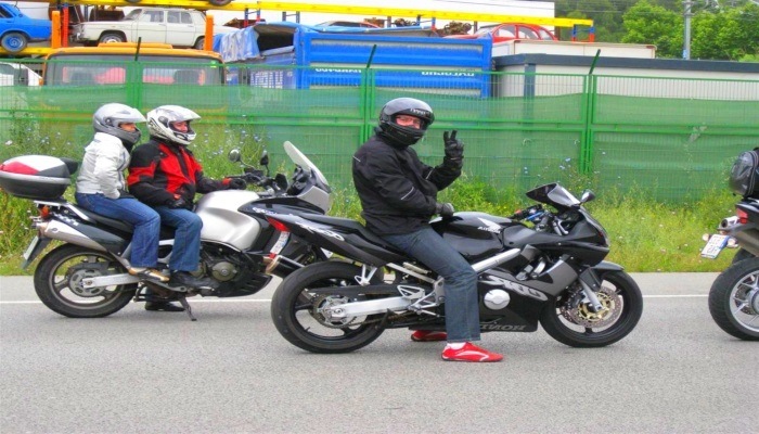 motorista saludando en V mirando a la cámara